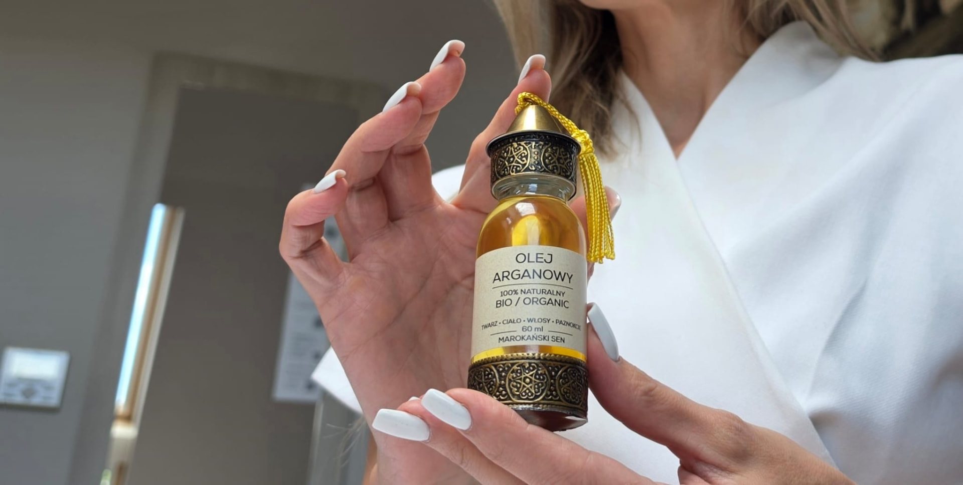 Olej Arganowy 100% Naturalny BIO 60 ml Marokański Sen w ozdobnej butelce trzymanej w dłoniach